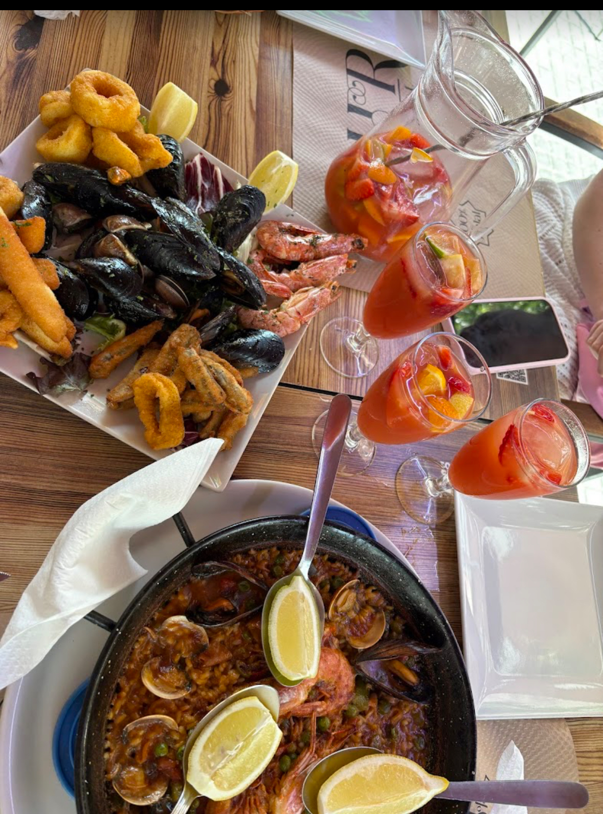 Mesa con paella, marisco frito y bebidas en Restaurant Nour
